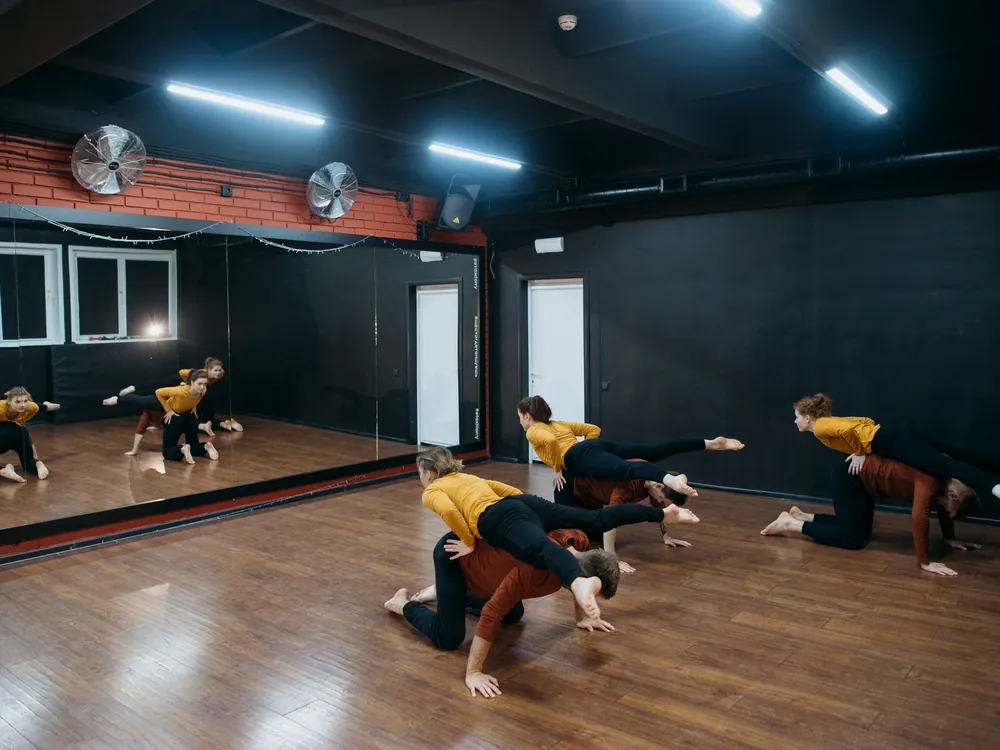 A group working low across a studio floor