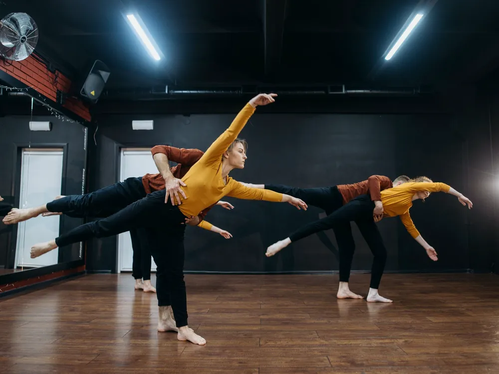 Two dancers with arms extended
