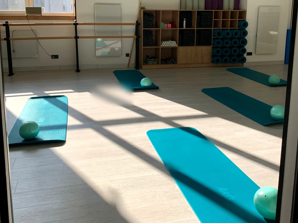 Exercise mats across a sunlit studio floor
