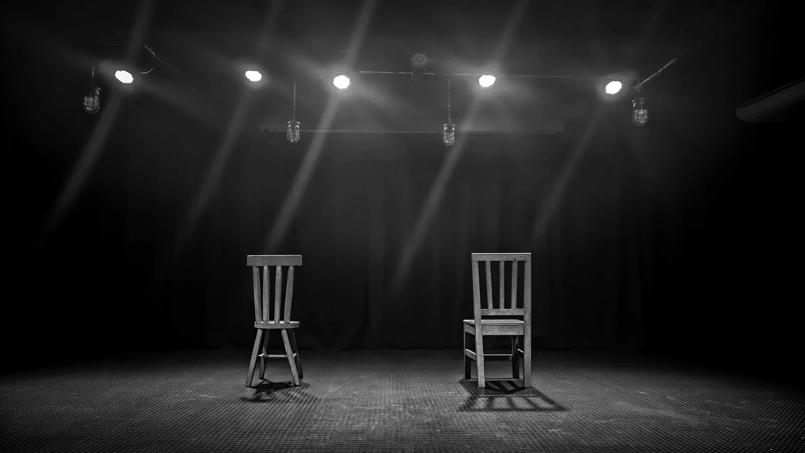 Two chairs on a lit empty stage
