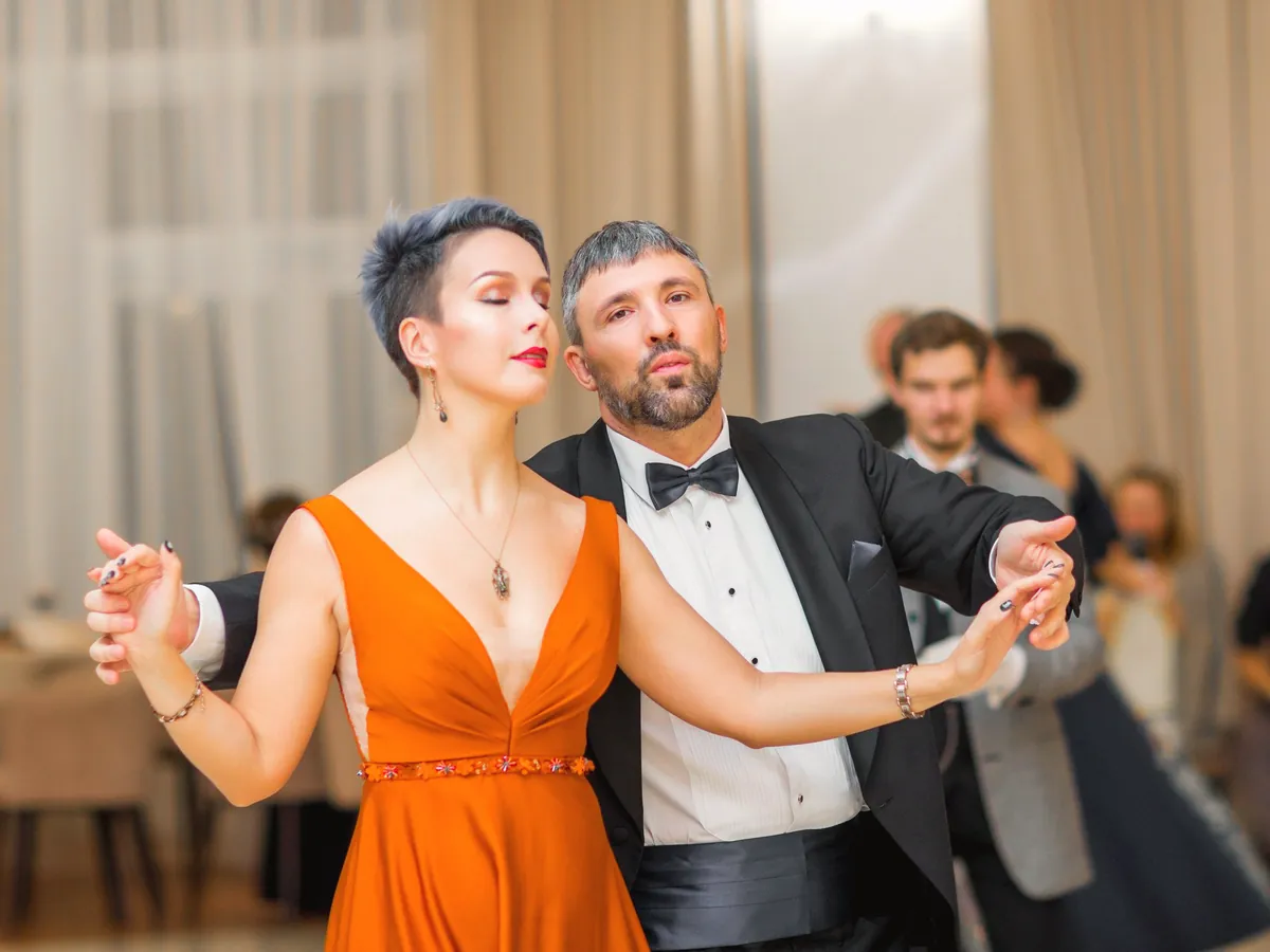 A couple in evening wear dancing in a ballroom