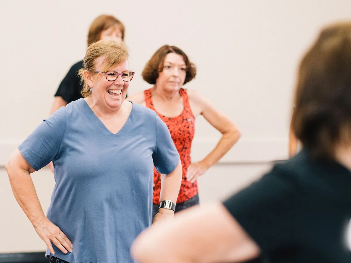 Adults laughing during a beginner dance class