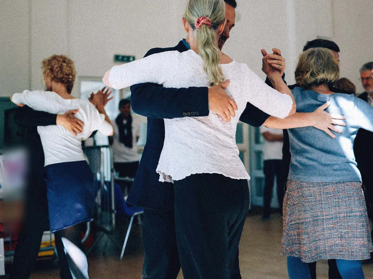 Adult couples practising in a bright hall