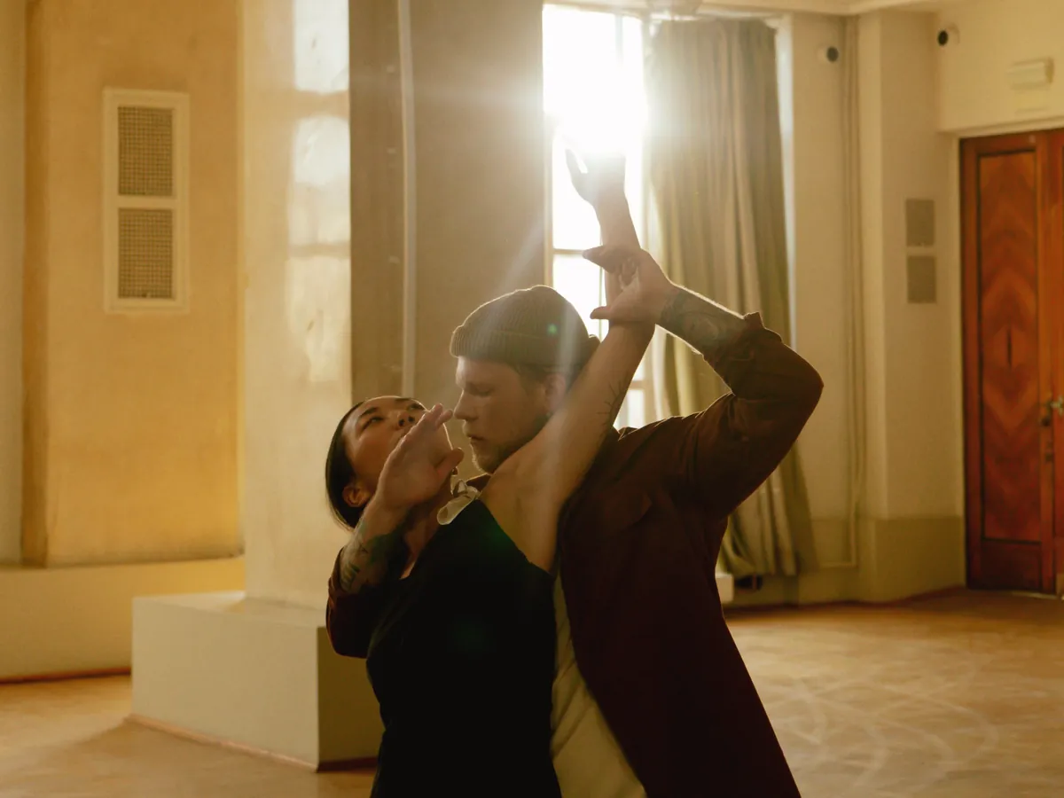 A couple practising in a sunlit hall