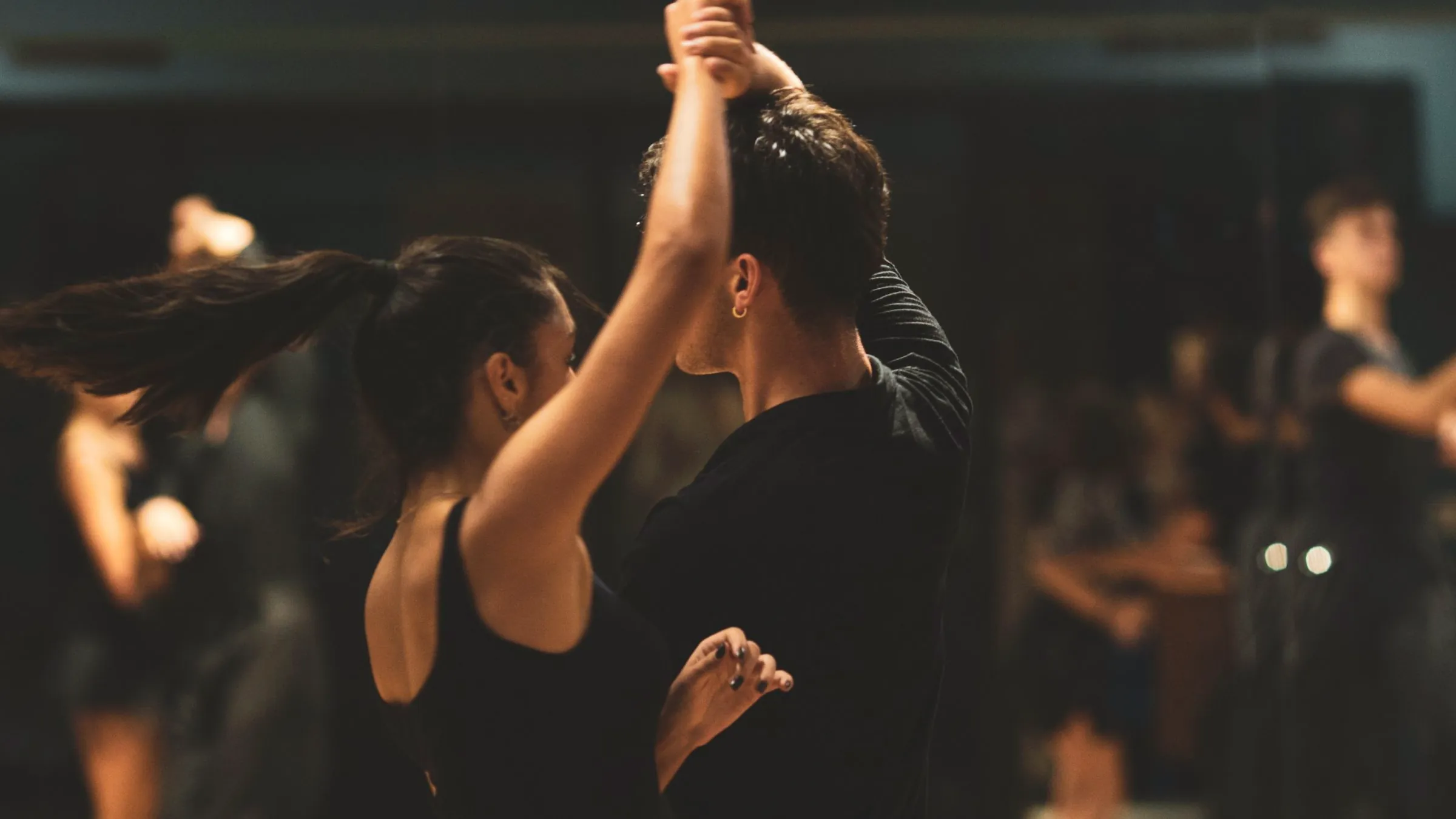 A dark dance floor at night with couples turning