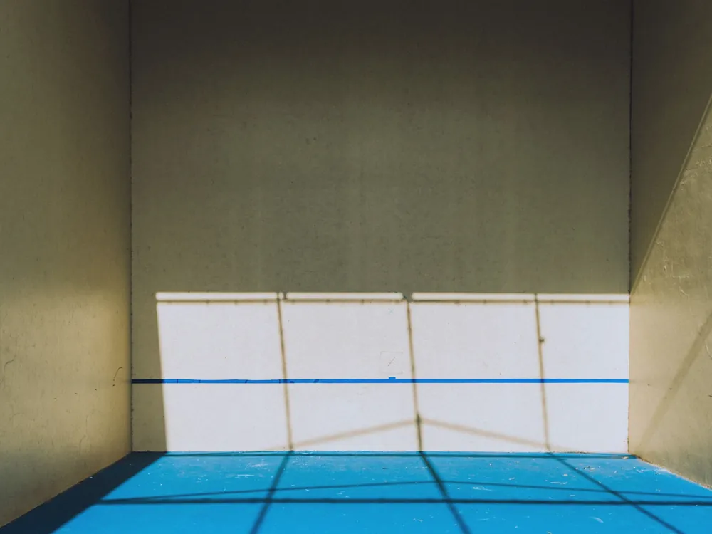 An empty squash court in sunlight