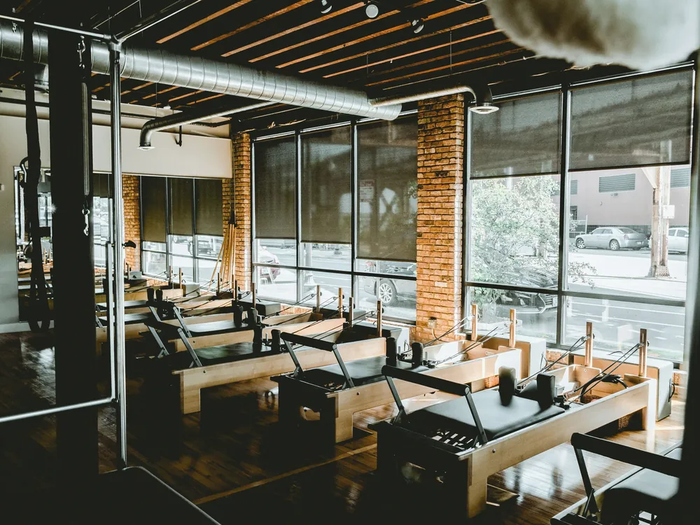 A studio of training machines by tall windows