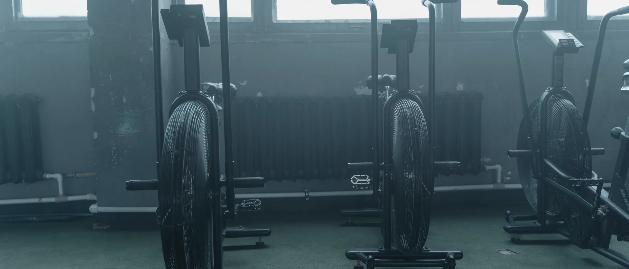 Air bikes in a row in a hazy gym