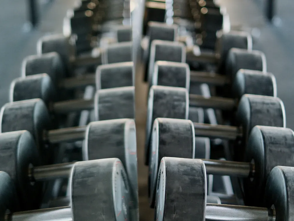 A long dumbbell rack seen in a mirror