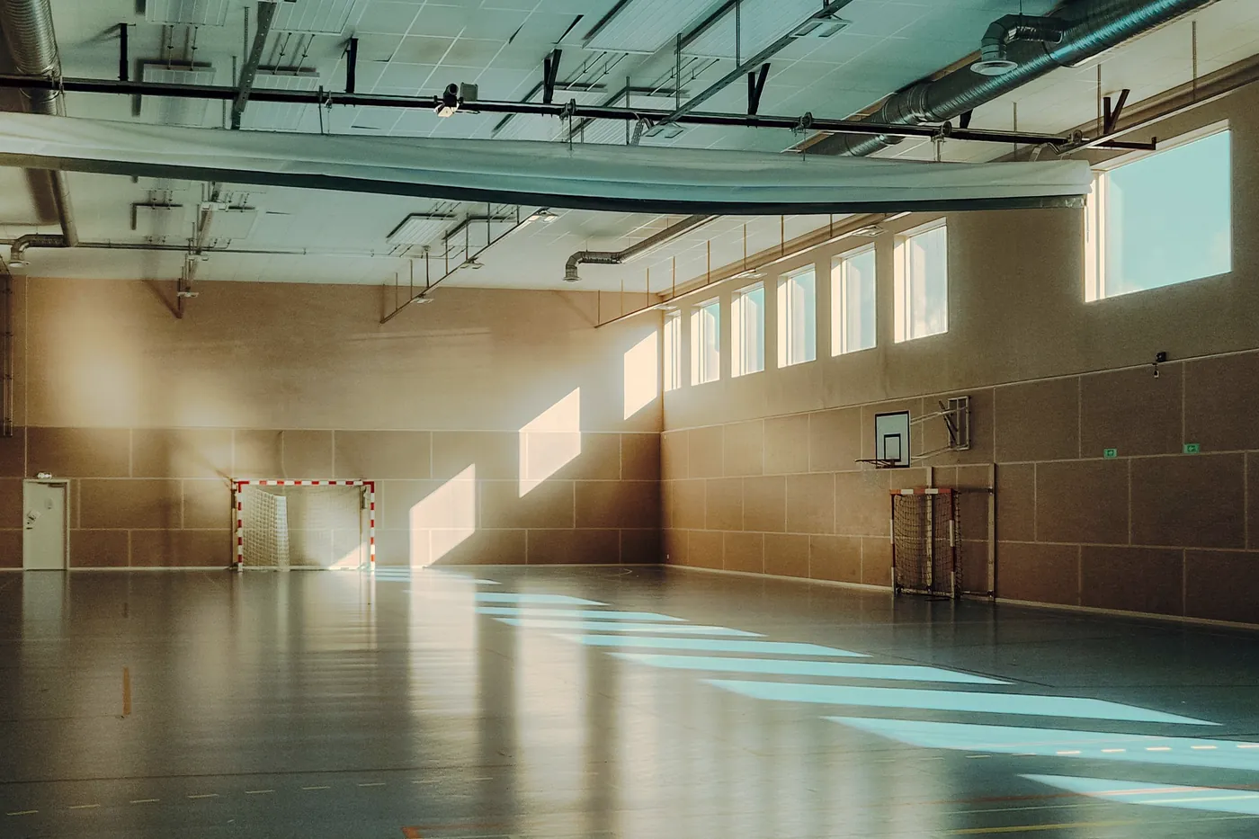 A sunlit gym hall with nobody in it