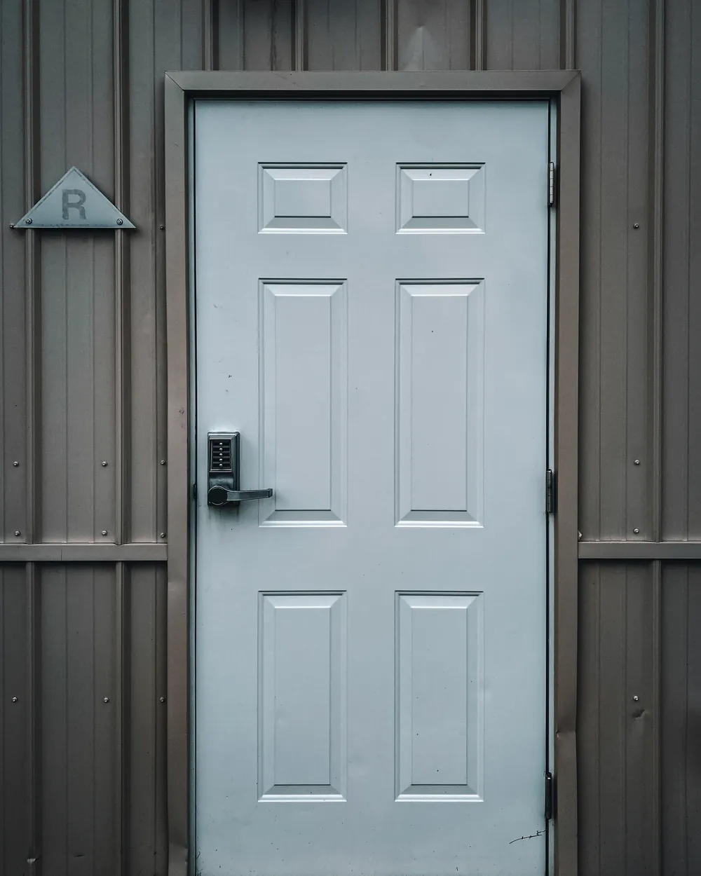 A pale door with a modern lock