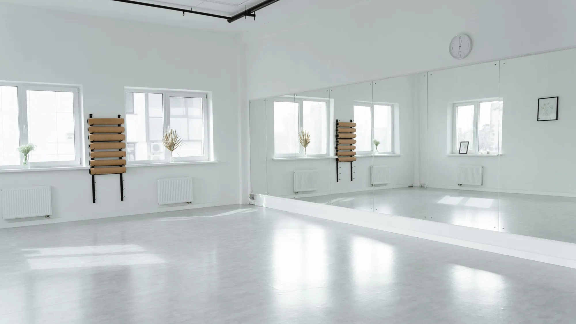 A training room, empty, with a mirror wall and daylight from the windows