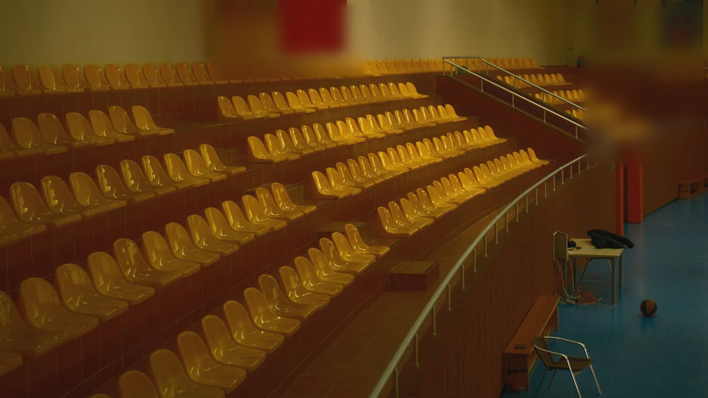 Rows of empty spectator seats above a gym floor