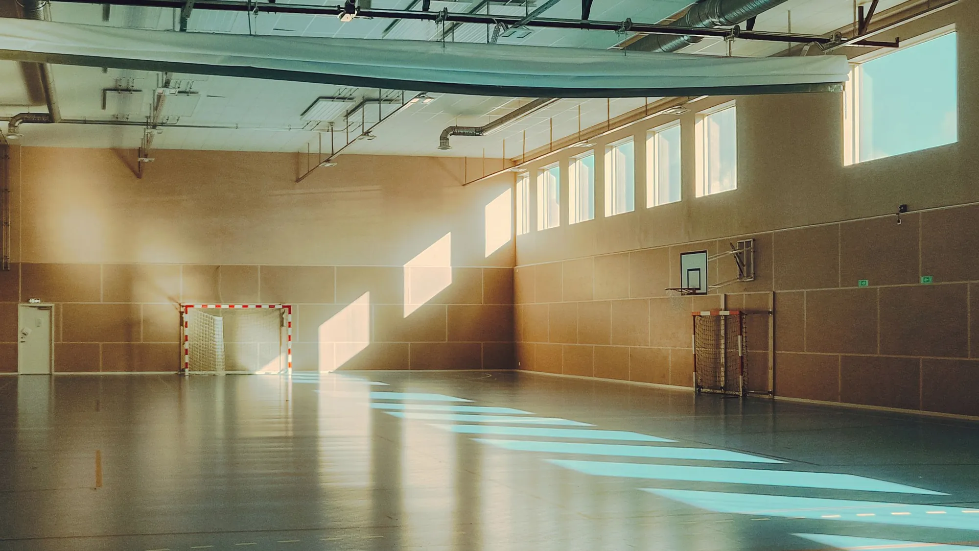 A wide empty hall with sunlight across the floor