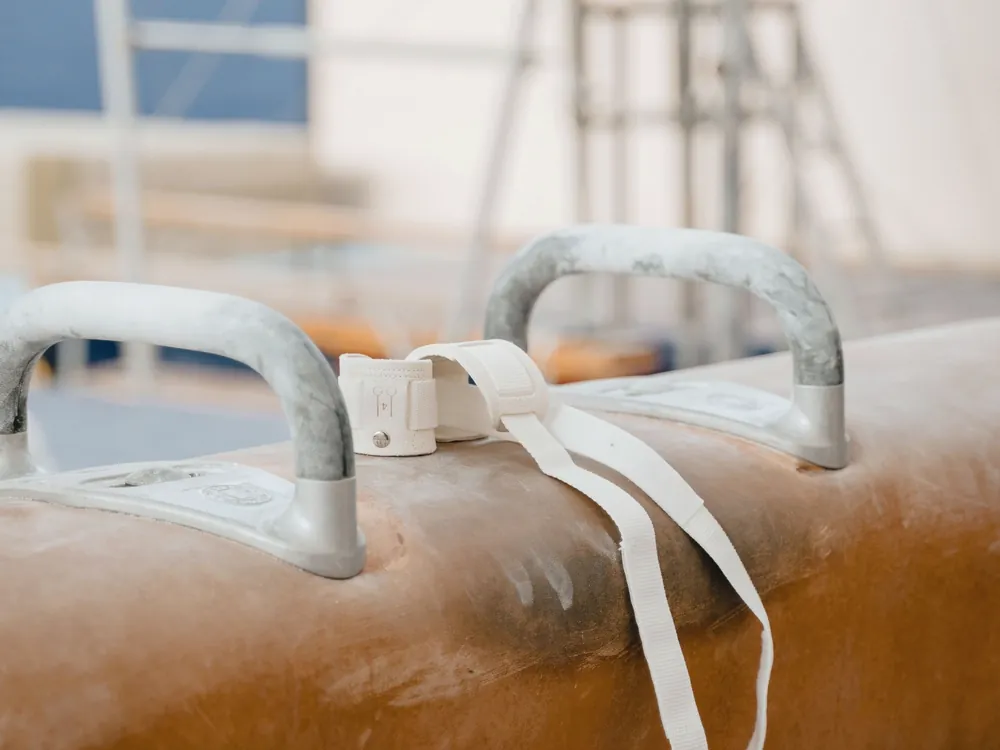 A pommel horse handle with a wrist strap