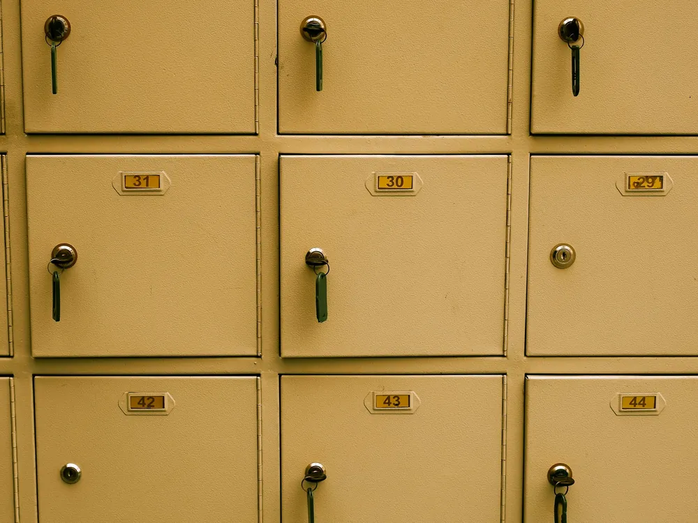 A wall of numbered pigeonholes with keys in the locks