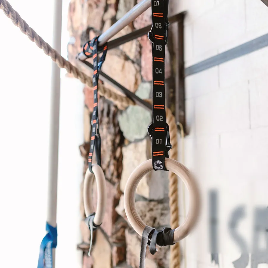 Wooden rings on straps beside a stone wall