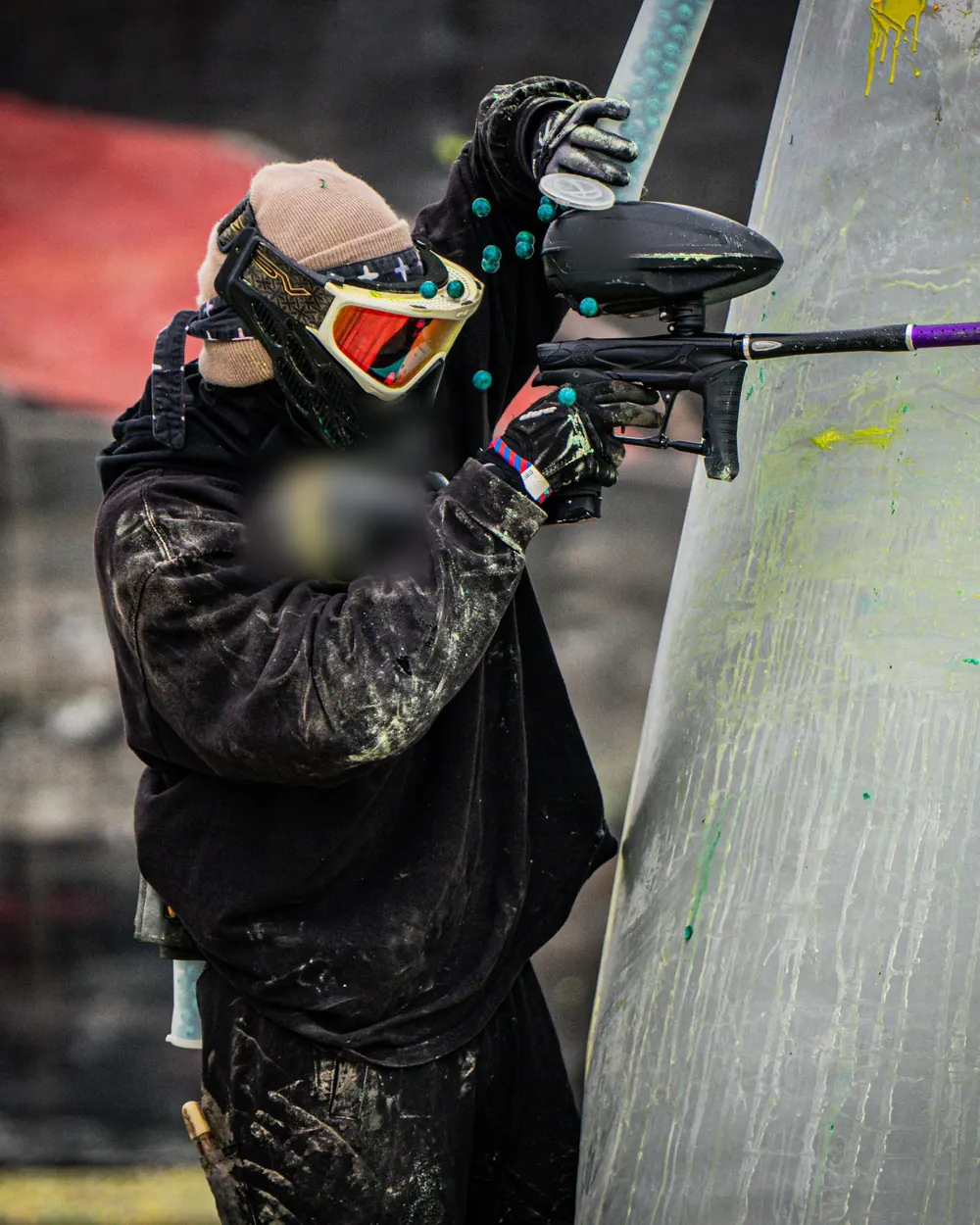 A single masked adult player behind a bunker, face fully covered