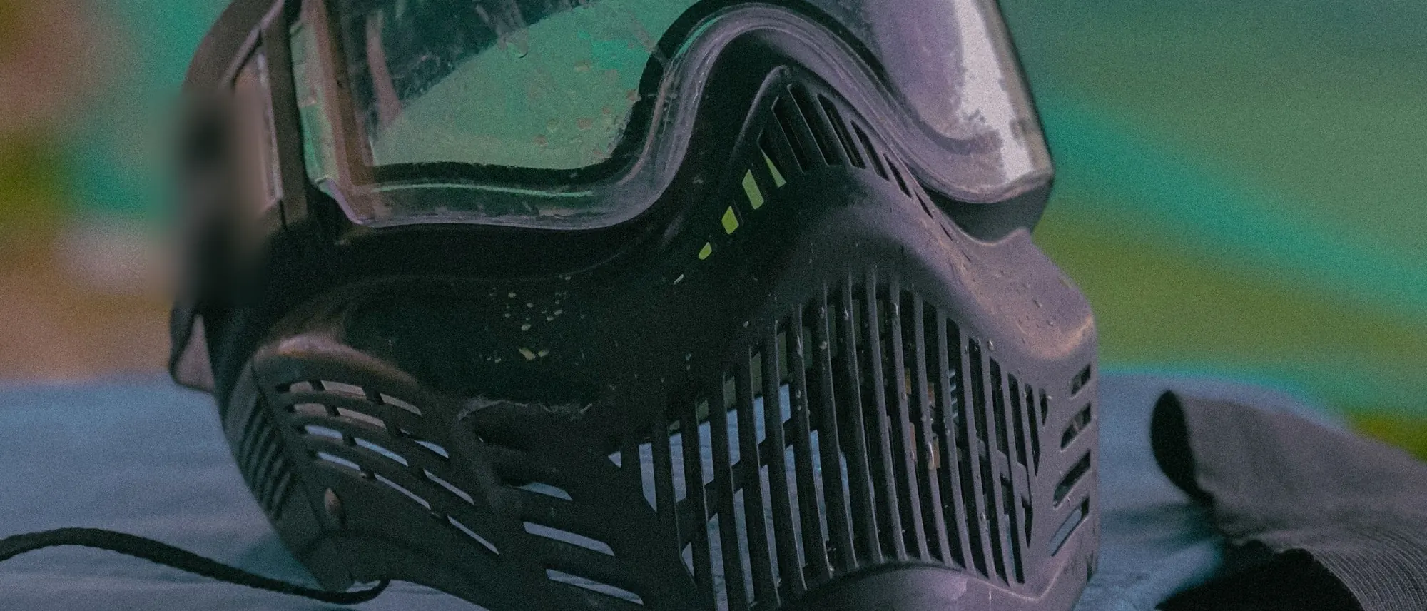 A paintball mask on a bench, wide